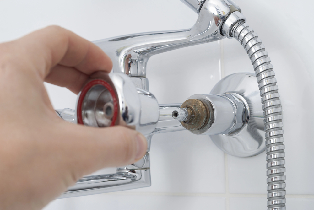 Hand adjusting a chrome faucet handle, illustrating plumbing maintenance for Plumb Right plumbing services.